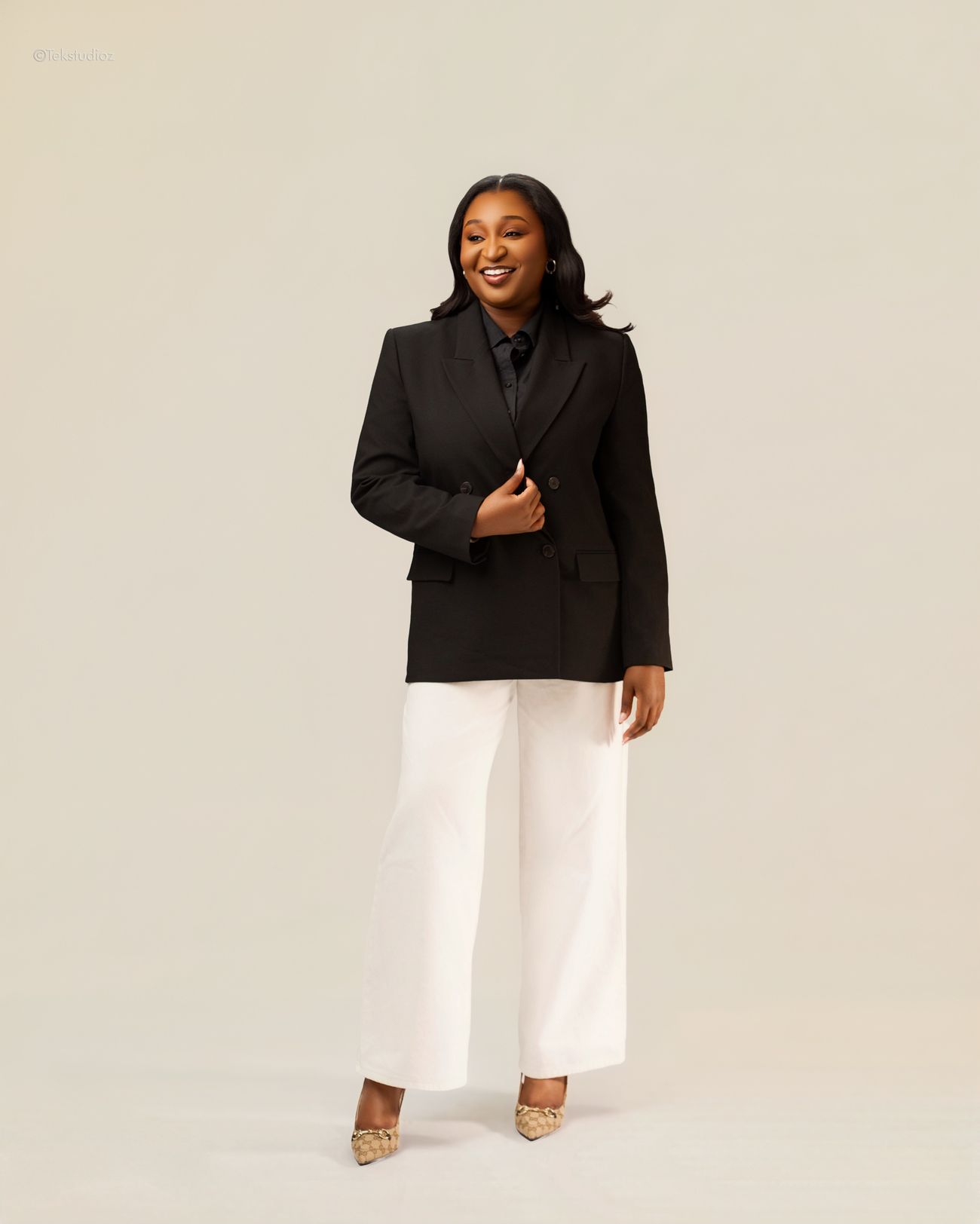Toju Temile in a black double breasted blazer and white trousers